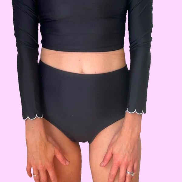 High Waist Black Swim Bottoms on model showing scalloped sleeve trim and high-waisted fit with crop top