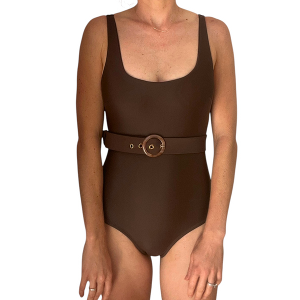 Woman wearing brown Chocolate One Piece swimsuit with circular belt buckle detail at waist