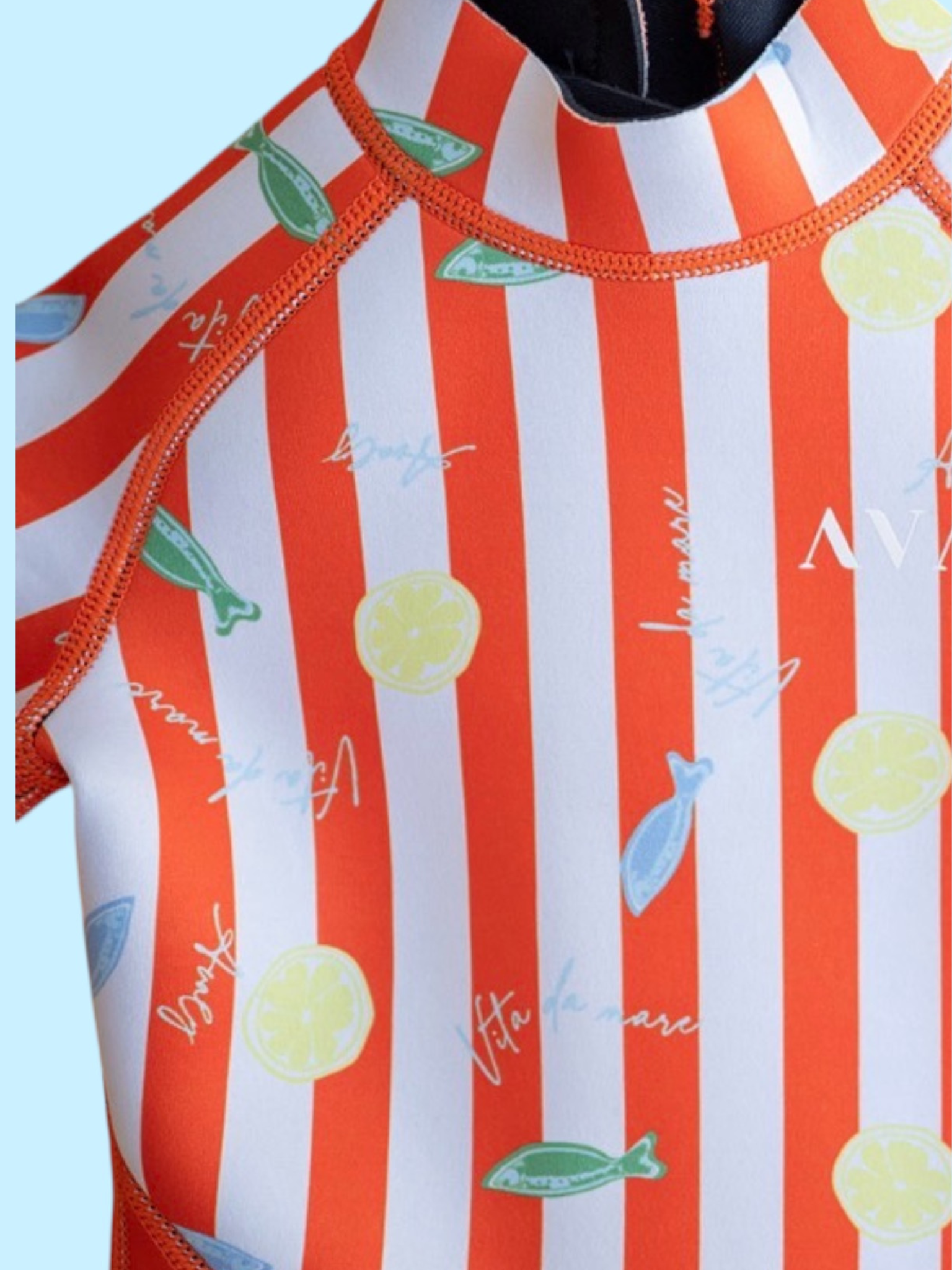 Detail shot of Amalfi Fish Kids Wetsuit showing red and white striped pattern with yellow lemons and green fish graphics