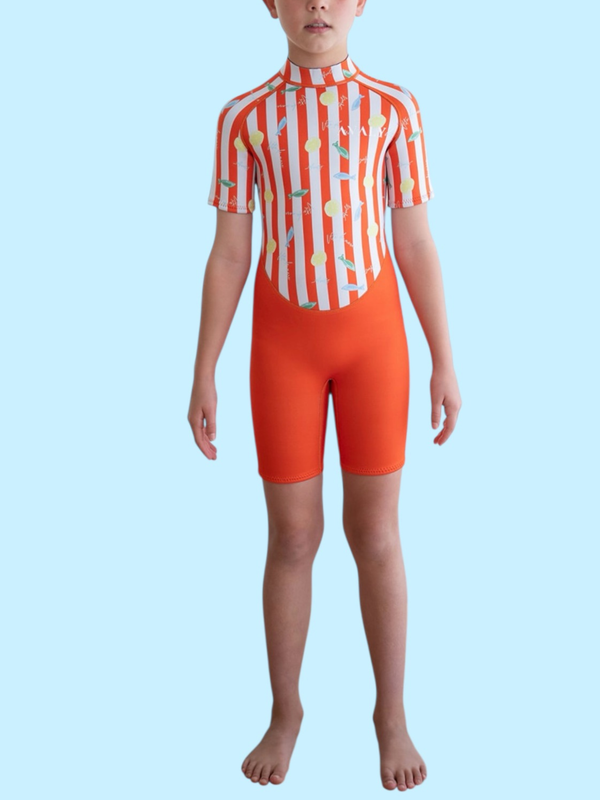Child model wearing Amalfi Fish Kids Wetsuit with orange and white striped top featuring colorful fish print and solid orange shorts