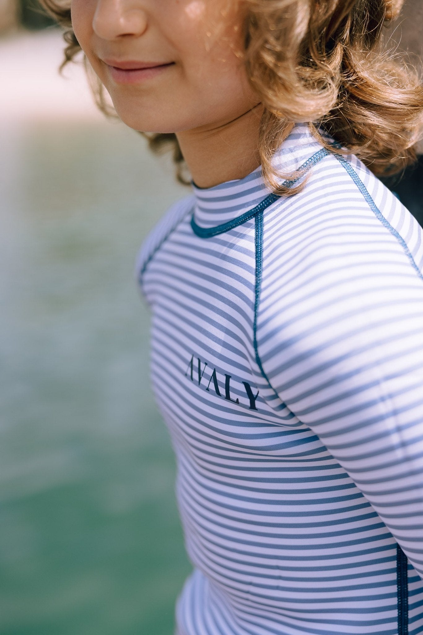 Child wearing Navy & White Striped Kids Sustainable Wetsuit showing horizontal stripe pattern and blue contrast stitching