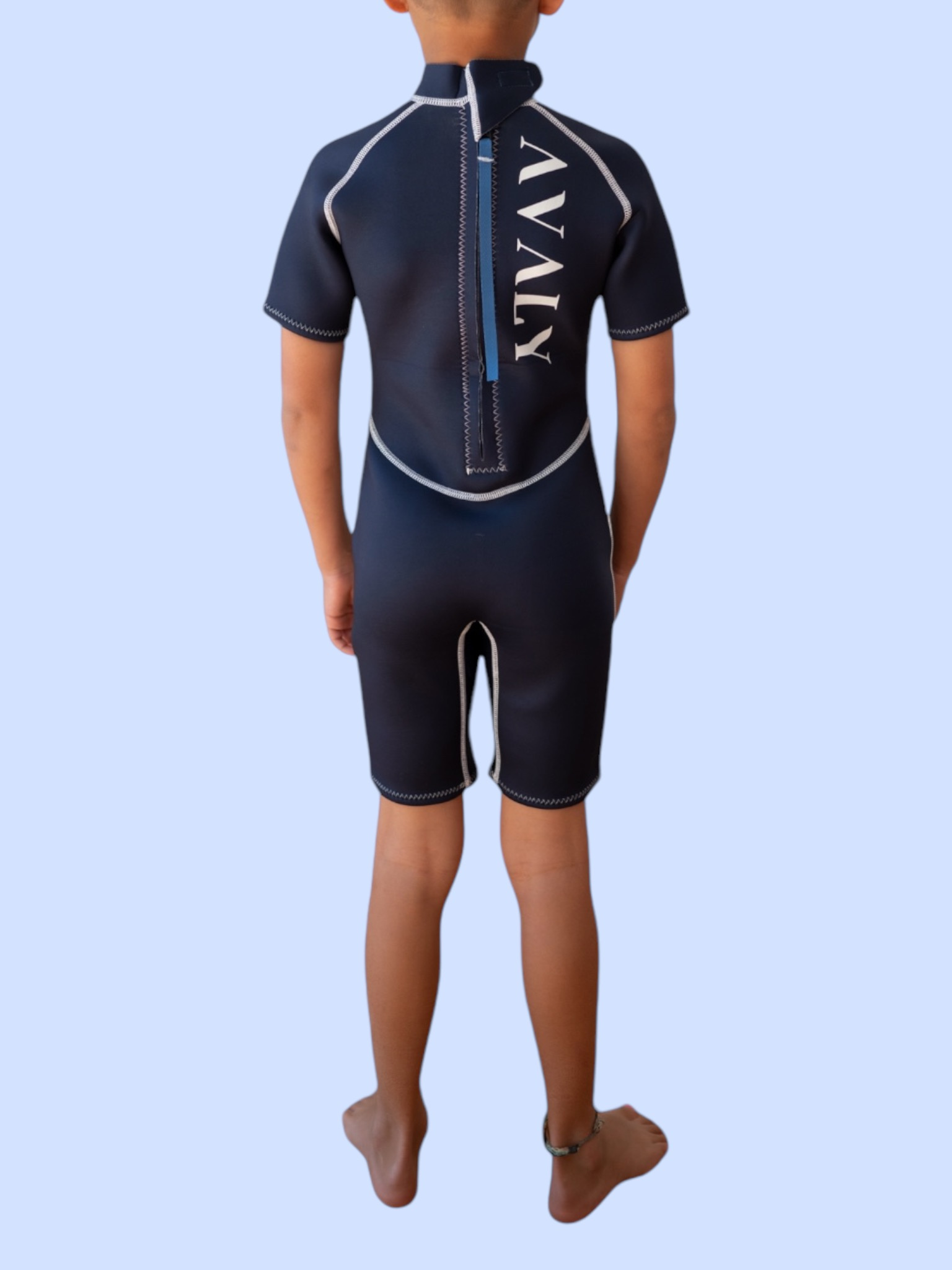 Back view of child wearing Solid Navy Kids Wetsuit showing full zip closure and Avaly branding