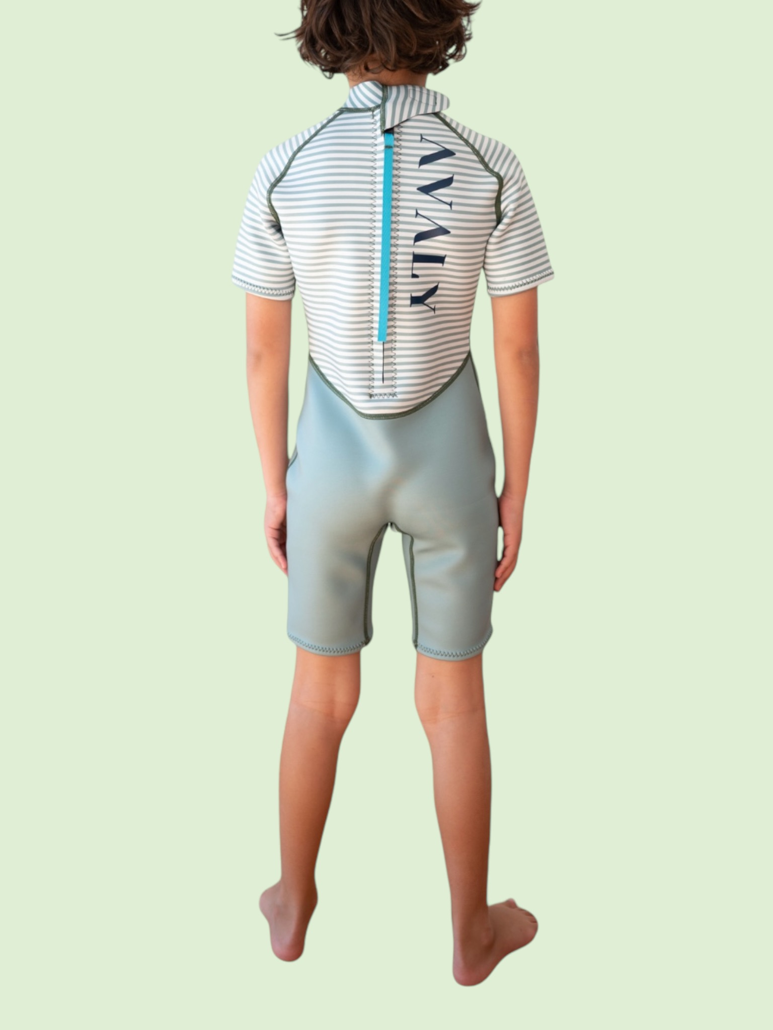 Back view of child wearing Green Stripe Kids Wetsuit showing striped rashie top and sage green neoprene shorts