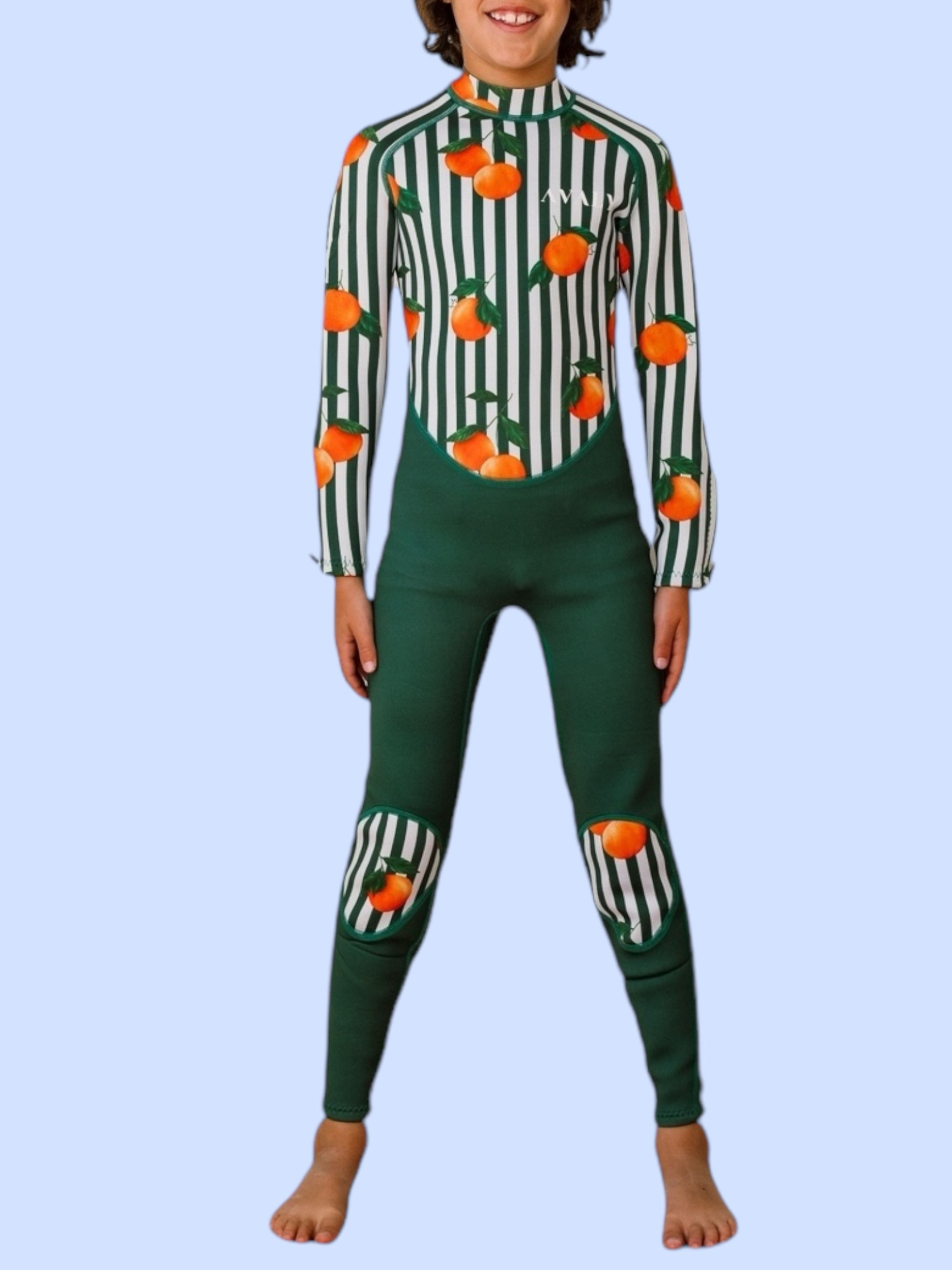 Child model wearing Forest Green & Mandarins wetsuit with orange fruit print on green and white striped design