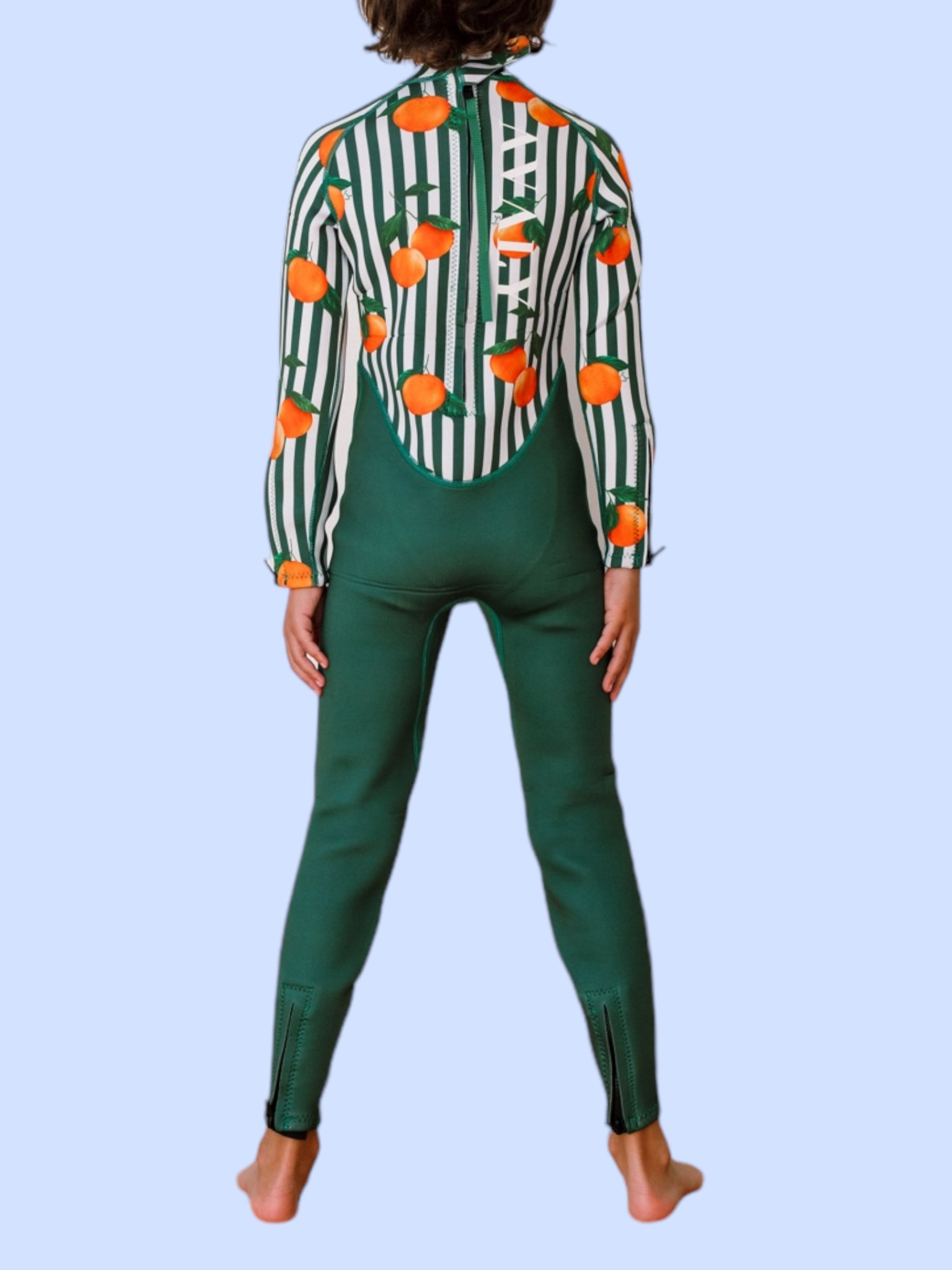 Back view of child wearing Forest Green & Mandarins wetsuit showing orange citrus print on striped sleeves and green leggings