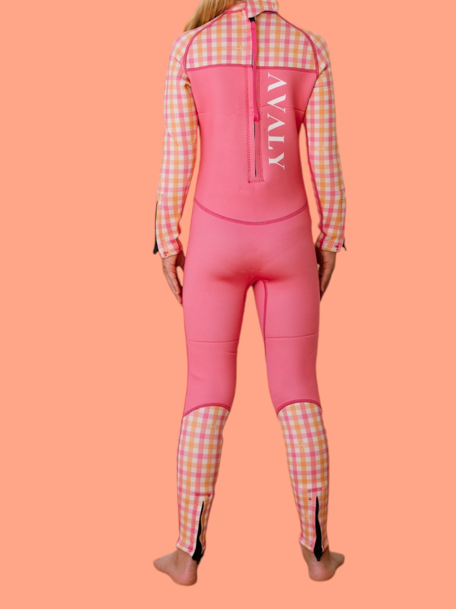 Back view of child model wearing Pink & Orange Gingham Sustainable Kids Wetsuit showing checkered sleeves and pink body