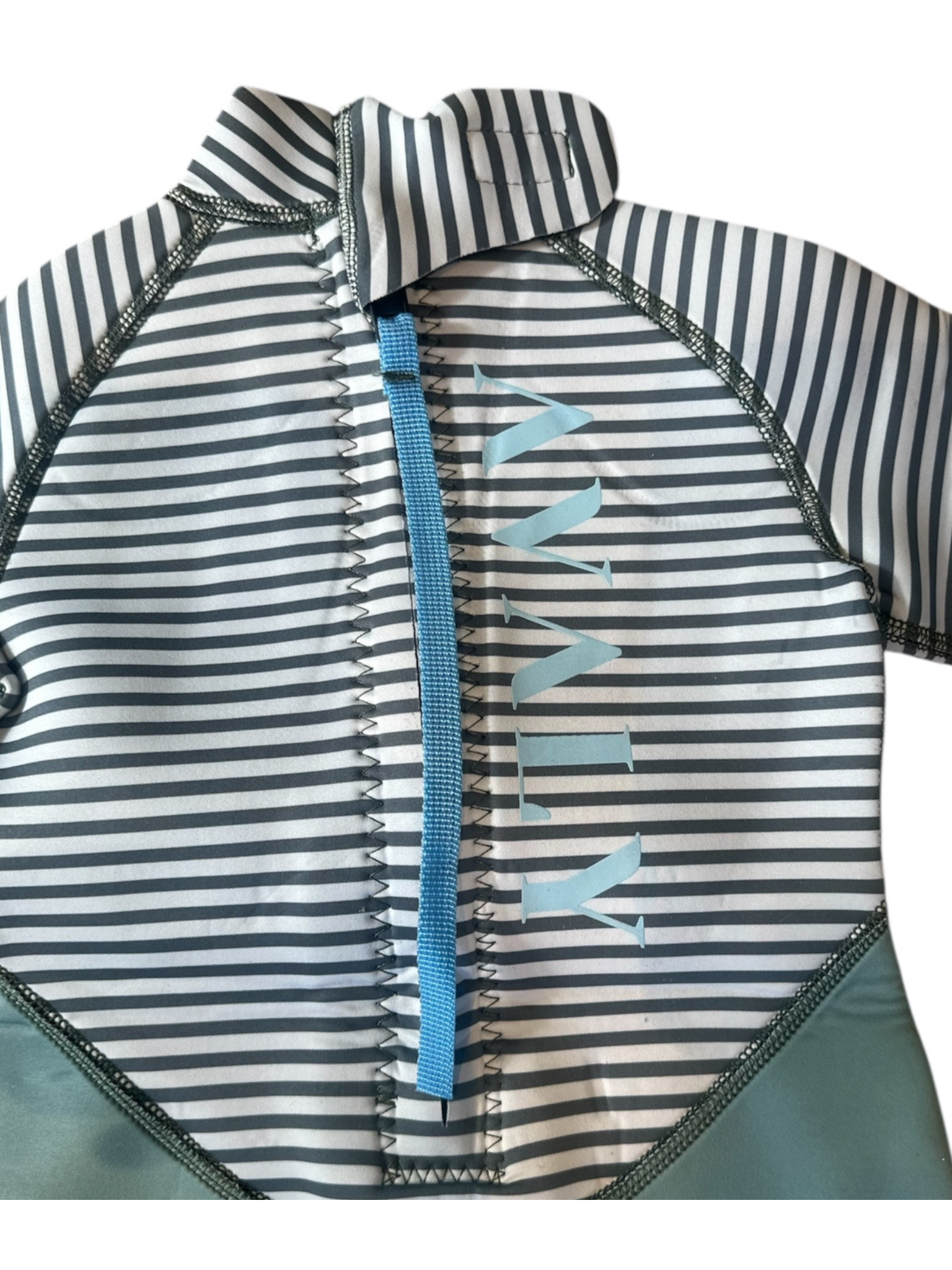 Close up detail of Sage and dark green striped wetsuit showing blue zipper pull and shark fin pattern on striped fabric