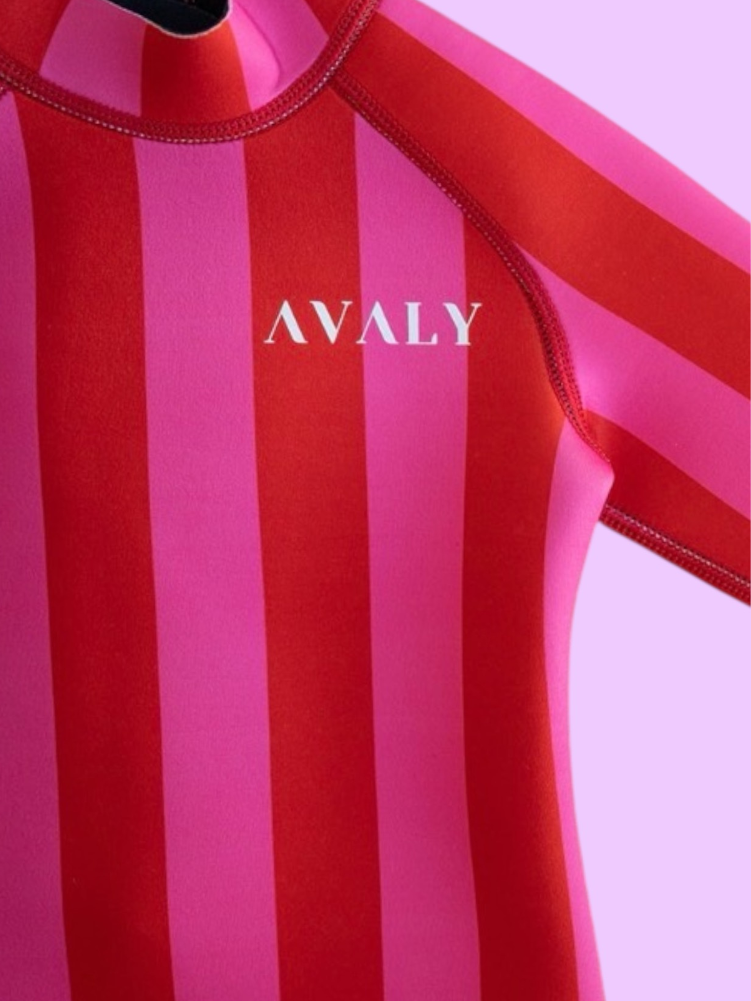 Close up detail of Pink & Red Stripe Kids Wetsuit showing vertical striped pattern and white Avaly logo on chest