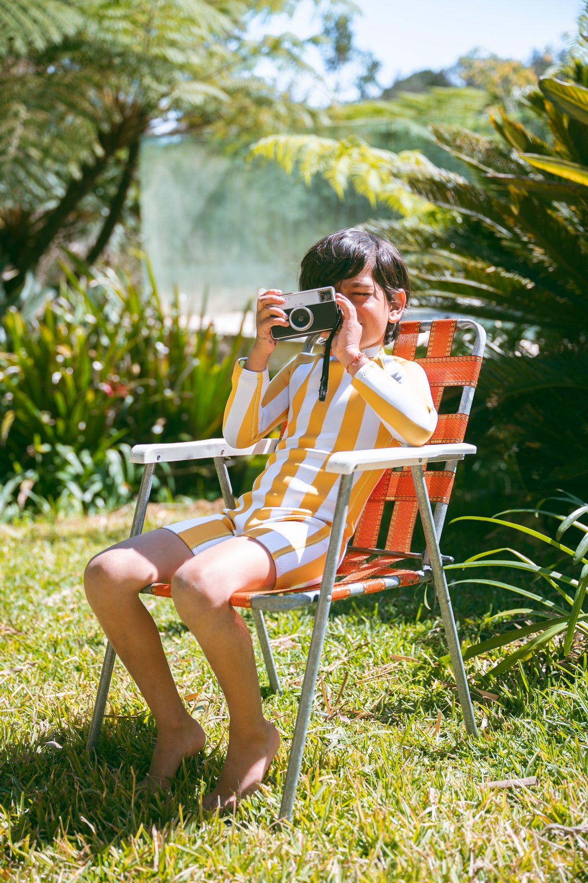 Child in an AVALY yellow striped springsuit