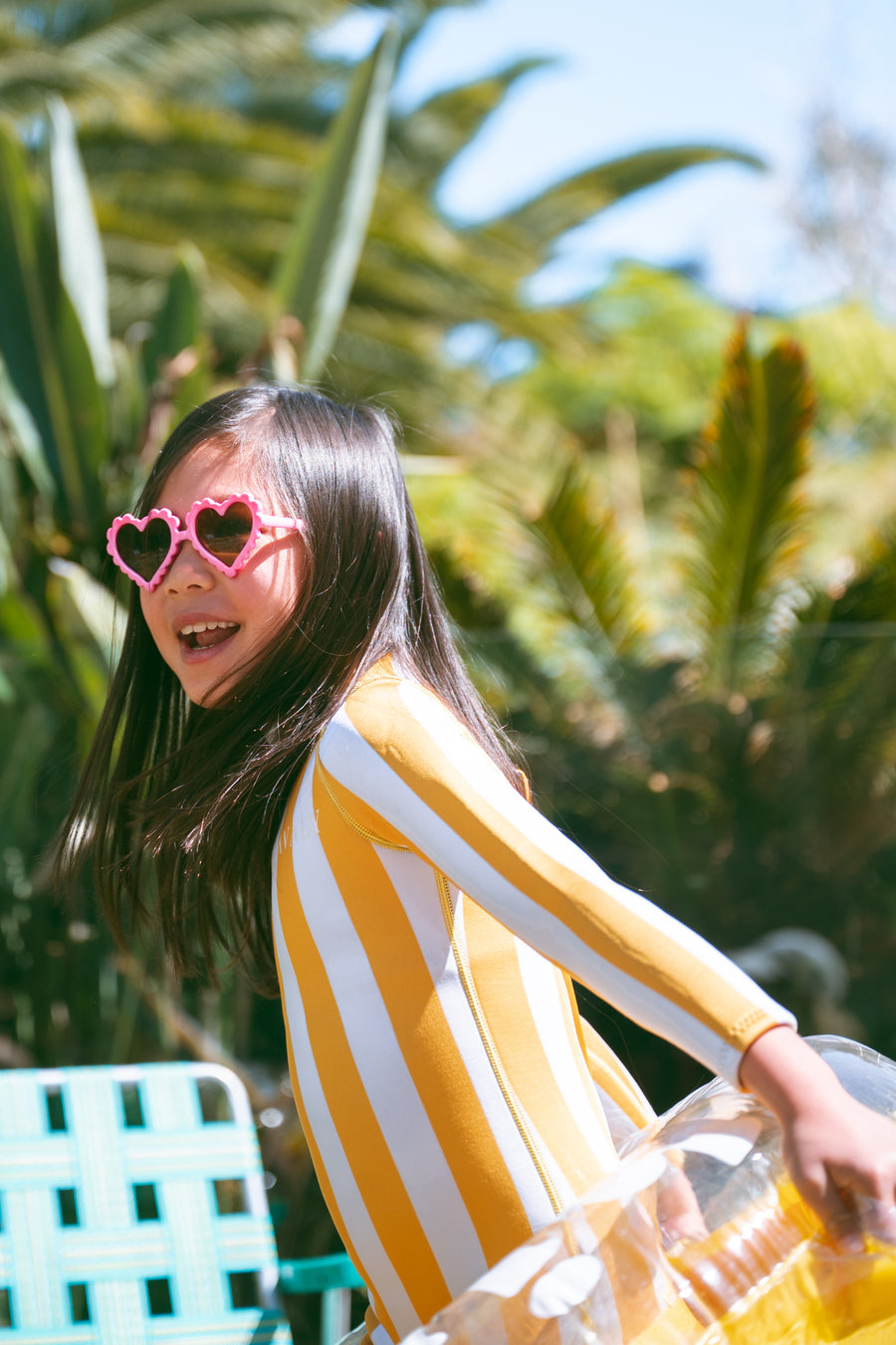 Girl in AVALY yellow striped swimwear — FSC certified sustainable materials