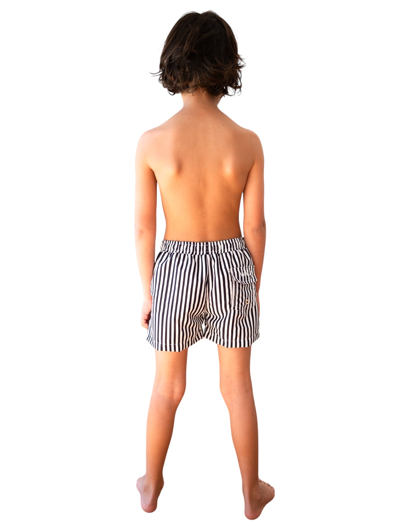Back view of child model wearing Navy Striped Board Shorts showing black and white vertical stripe pattern