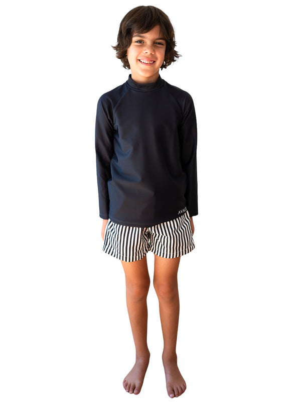 Boy wearing Navy Striped Board Shorts with black and white vertical stripes and navy long sleeve rashie