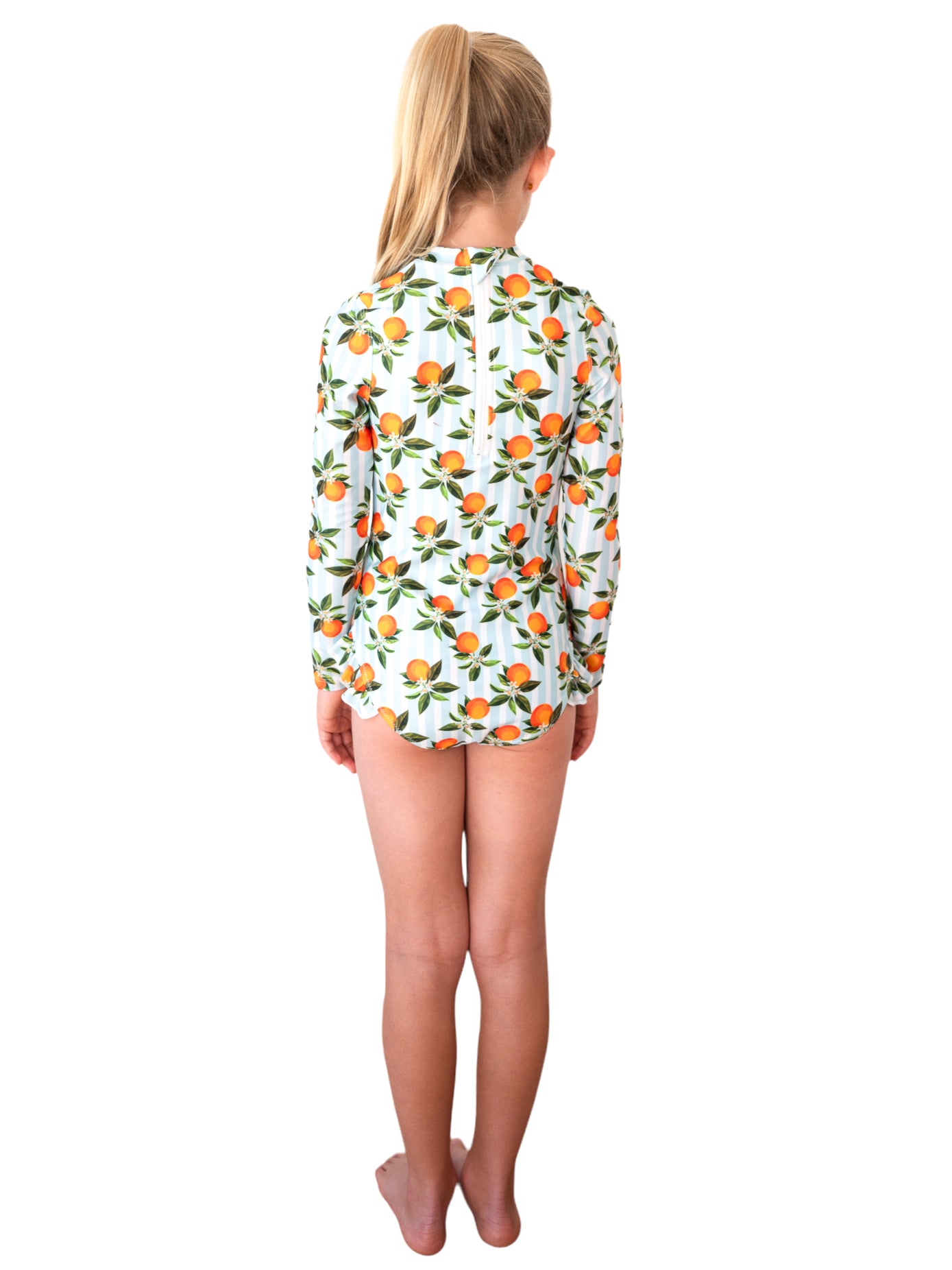 Back view of child model wearing Whitehaven Long Sleeve One Piece with orange citrus fruit print on white background