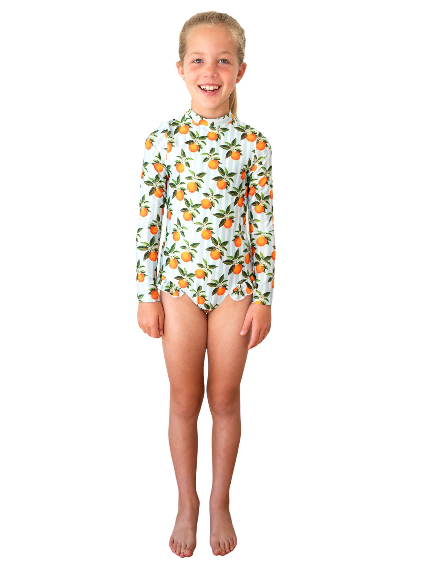 Girl wearing Whitehaven Long Sleeve One Piece with orange citrus fruit print on light blue background