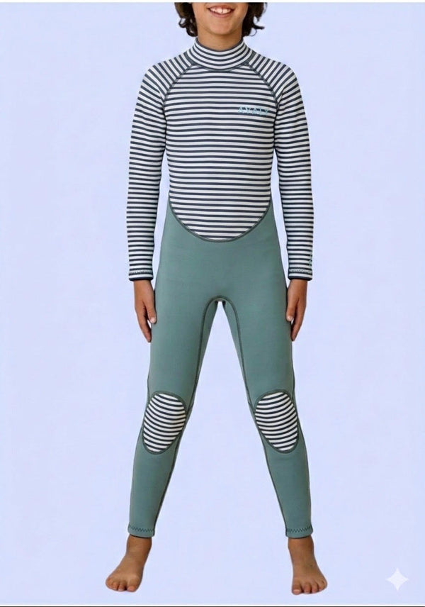 Child wearing sage green wetsuit with navy and white striped long sleeves and knee panels, standing against light purple background